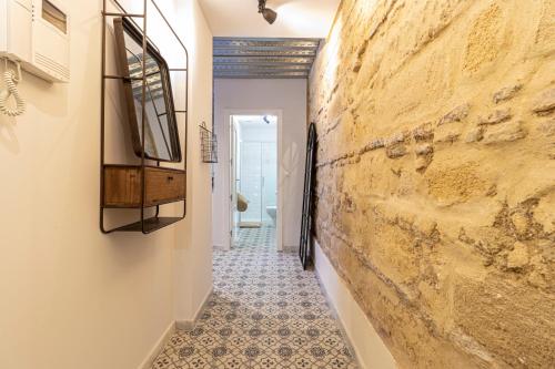 corridoio con parete in pietra e pavimento piastrellato di Allo Apartments San Francisco Centro Loft a Jerez de la Frontera