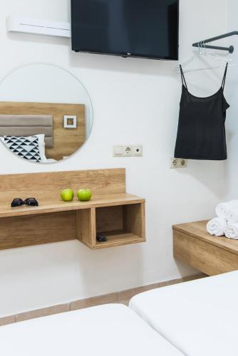 a living room with a tv and a wooden shelf at Vagelis Apartments Malia in Malia
