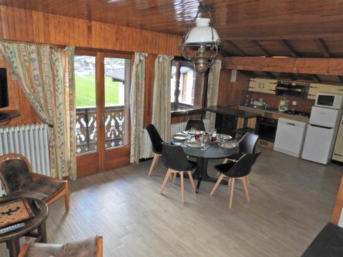 une cuisine et une salle à manger avec une table et des chaises dans l'établissement Manoir 3 appt Les Gets, aux Gets