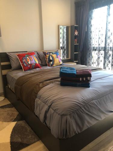 a bedroom with a bed with pillows and a window at Marvest Hua Hin flat B 208 3.fl. Betw.Soi 78-80 in Hua Hin