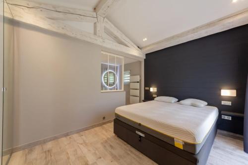 - une chambre avec un lit et un mur noir dans l'établissement Villa les trois J, à Grimaud