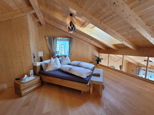 1 dormitorio con 1 cama en una habitación con techos de madera en Ferienwohnung Anna Salzburg Grödig en Grödig