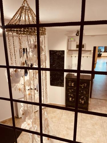 a view through a window of a room with a chandelier at Casa Pisica Noastra in Breaza
