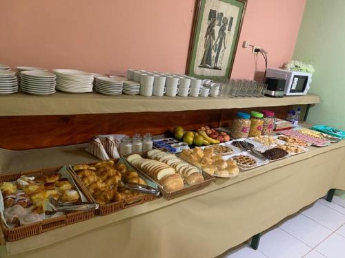 una línea de buffet con diferentes tipos de pan y repostería en Hotel Itavera en Puerto Iguazú