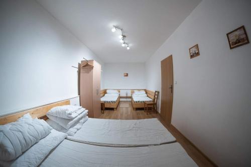 a white room with a bed and a table at Apartmány stará škola in Horní Bečva