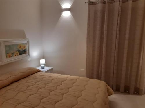 a bedroom with a bed and a light on the wall at San Domenico Casa Vacanze in Modica