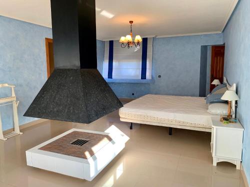 Chalet 5 dormitorios con piscina y jardín في لا مانغا ذيل مار مينور: غرفة نوم فيها سرير وموقد
