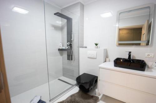 biała łazienka z umywalką i prysznicem w obiekcie Postavaru Studio w mieście Poiana Brașov