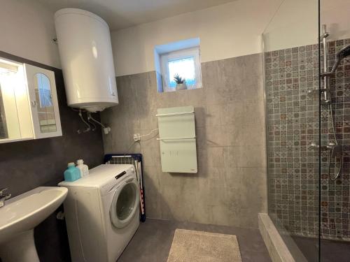 a bathroom with a washing machine and a sink at Corte Apartman in Pápa