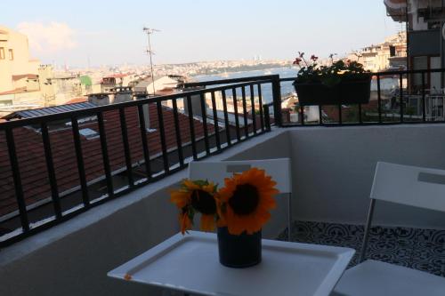 Cute Flat Cihangir في إسطنبول: مزهرية مع الزهور تجلس على طاولة على شرفة