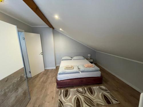 um pequeno quarto com uma cama no sótão em Apartments Don em Belgrado