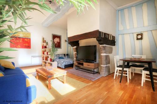 a living room with a blue couch and a fireplace at Le Saint Georges, Centre historique proche gare in Rennes