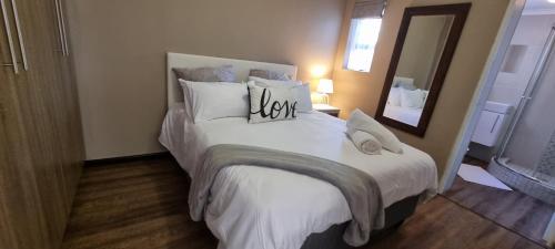 um quarto com uma grande cama branca e um espelho em Spacious Cottage em Mount Road