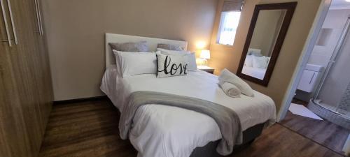 una camera da letto con un grande letto bianco e uno specchio di Spacious Cottage a Mount Road