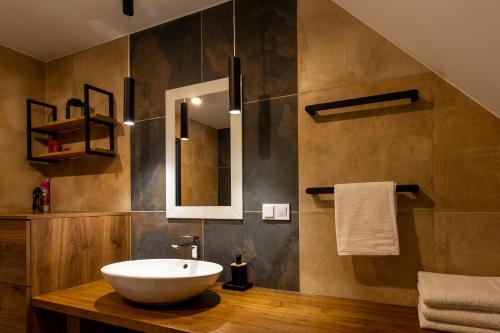 a bathroom with a sink and a mirror at Domek na Wzgórzu in Rymanów-Zdrój