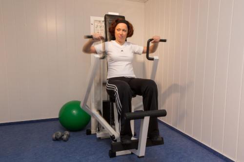 a woman sitting in a chair with a barbell at Landhotel Schöll in Parsberg