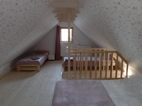 um quarto no sótão com uma escada e uma cama em Domek Na Leśnym Wzgórzu em Pieszyce