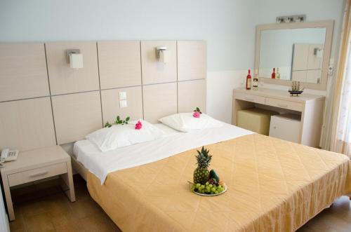 Un dormitorio con una cama con un bol de fruta. en Athos Hotel, en Nydri