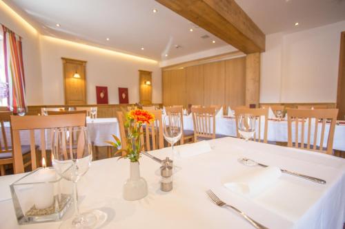 a dining room with a white table with flowers in a vase at Landhotel Schöll in Parsberg