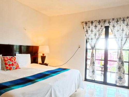 a bedroom with a bed and a large window at Casa De Los Pájaros - B&B in Valladolid