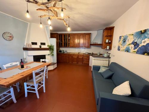 una cucina e un soggiorno con divano blu e tavolo di Rocca di Corno Guest House a Finale Ligure