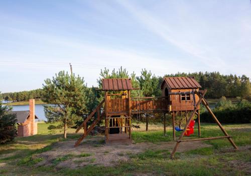 a playground with a tree house and a slide at Lobeliowy Port in Borzyszkowy