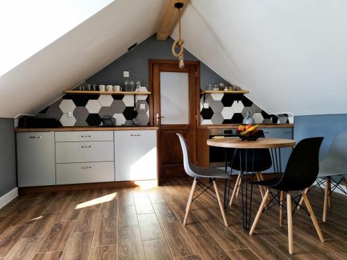 a kitchen with a table and chairs in a attic at Apartament w Jałowcach in Gronków