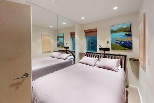 Duas camas num quarto com paredes brancas em Chic Condo Unit 1 em Aspen