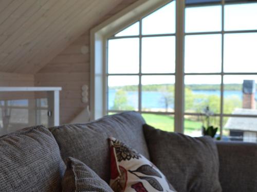 a couch with pillows in a living room with windows at Sjöbredareds Gård in Hökerum