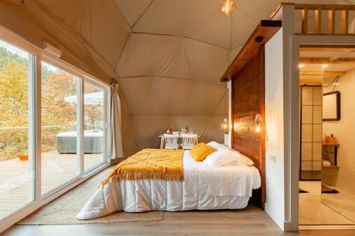 a bedroom with a bed and a large window at Refúgio das Poldras in Mondim de Basto