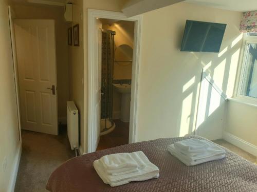 a bedroom with two white towels on a bed at The Eaves in Lynton, Exmoor, Devon in Lynton