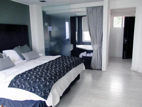 - une chambre avec un lit noir et blanc dans l'établissement Winery Hotel Boutique, à Algarrobo