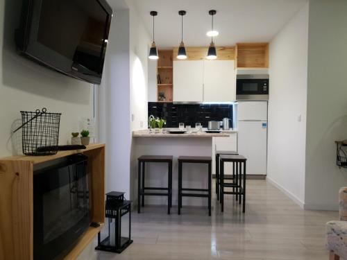a kitchen with a bar with stools in it at Henriqueta Maia Suits in Ílhavo