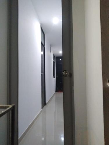 a hallway with white walls and a door and a hallway with black doors at La Petite Maison in Nazca