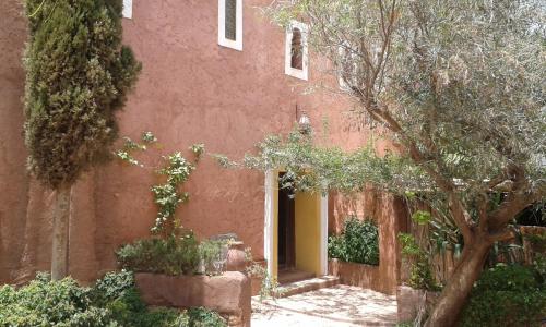 a red building with a tree in front of it at Riad Cascades d'Ouzoud in Ouzoud