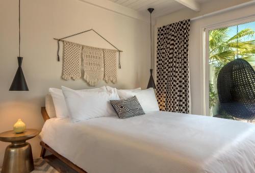 a white bed in a room with a window at the Weekend Palm Springs in Palm Springs