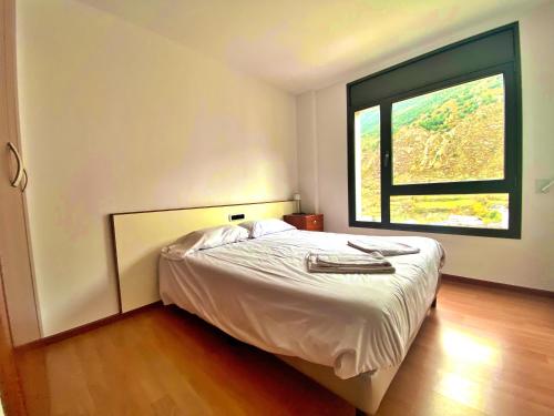 a bedroom with a bed with a large window at Tucamp 2,8 Al lado del Telecabina in Encamp