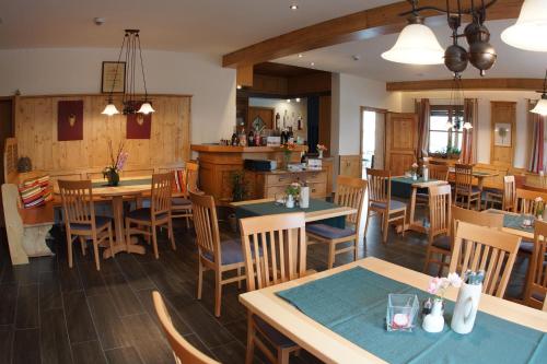 a restaurant with tables and chairs and a kitchen at Landhotel Schöll in Parsberg