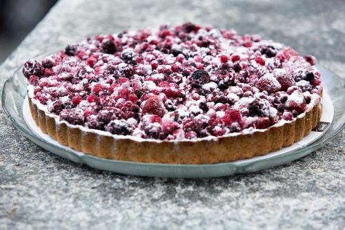 a pie with berries on a plate on a table at Hotel Ristorante Walser in Bosco Gurin