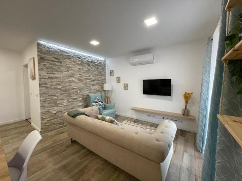 a living room with a couch and a tv at Charming Baixa III in Cabeço de Alhos Vedros