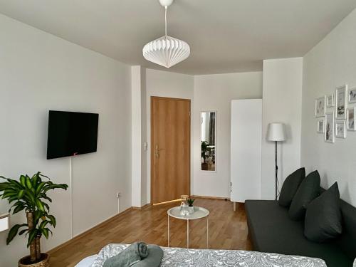 a living room with a couch and a tv at Modern & cozy Rooms Leipzig-Gohlis in Leipzig