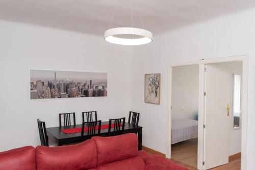a living room with a red couch and a table at Apartamento Alexa, a 800mts Catedral WiFi Smart TV in Murcia