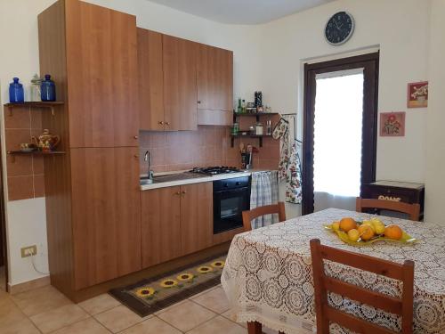 a kitchen with wooden cabinets and a table with oranges on it at Casa Lorica M&S in Lorica