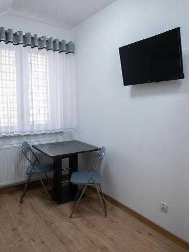 a dining room with a table and a tv on a wall at Agroturystyka u Aleksa in Krajno-Zagórze