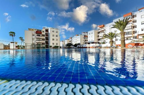 een leeg zwembad met gebouwen op de achtergrond bij Luxury 3 bedroom Perla Del Mar in Adeje