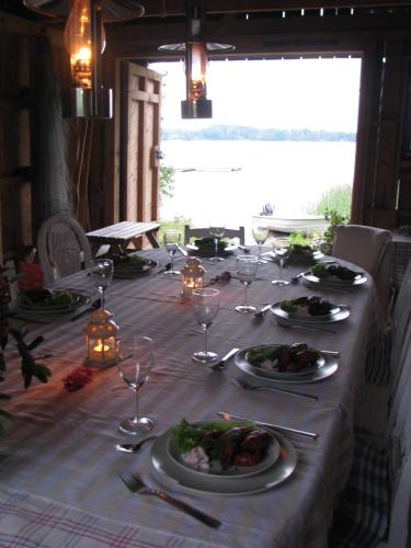 a long table with plates of food and wine glasses at Sjöbredareds Gård in Hökerum