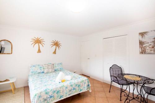a bedroom with a bed and a table and chairs at GORGEOUS STUDIO + 100M TO BEACH + POOL in Point Lookout