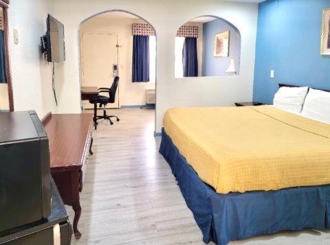 a hotel room with a bed and a desk at Americas Best Value Inn and Suites Houston/Northwest Brookhollow in Houston