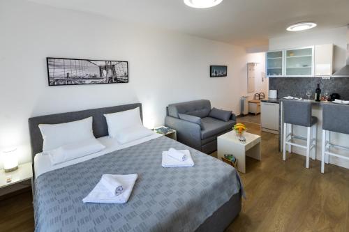 a small bedroom with a bed and a kitchen at MB Apartment 2 in Subotica