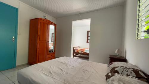 a bedroom with a bed and a wooden cabinet at LA DESIOR in Saint-Louis